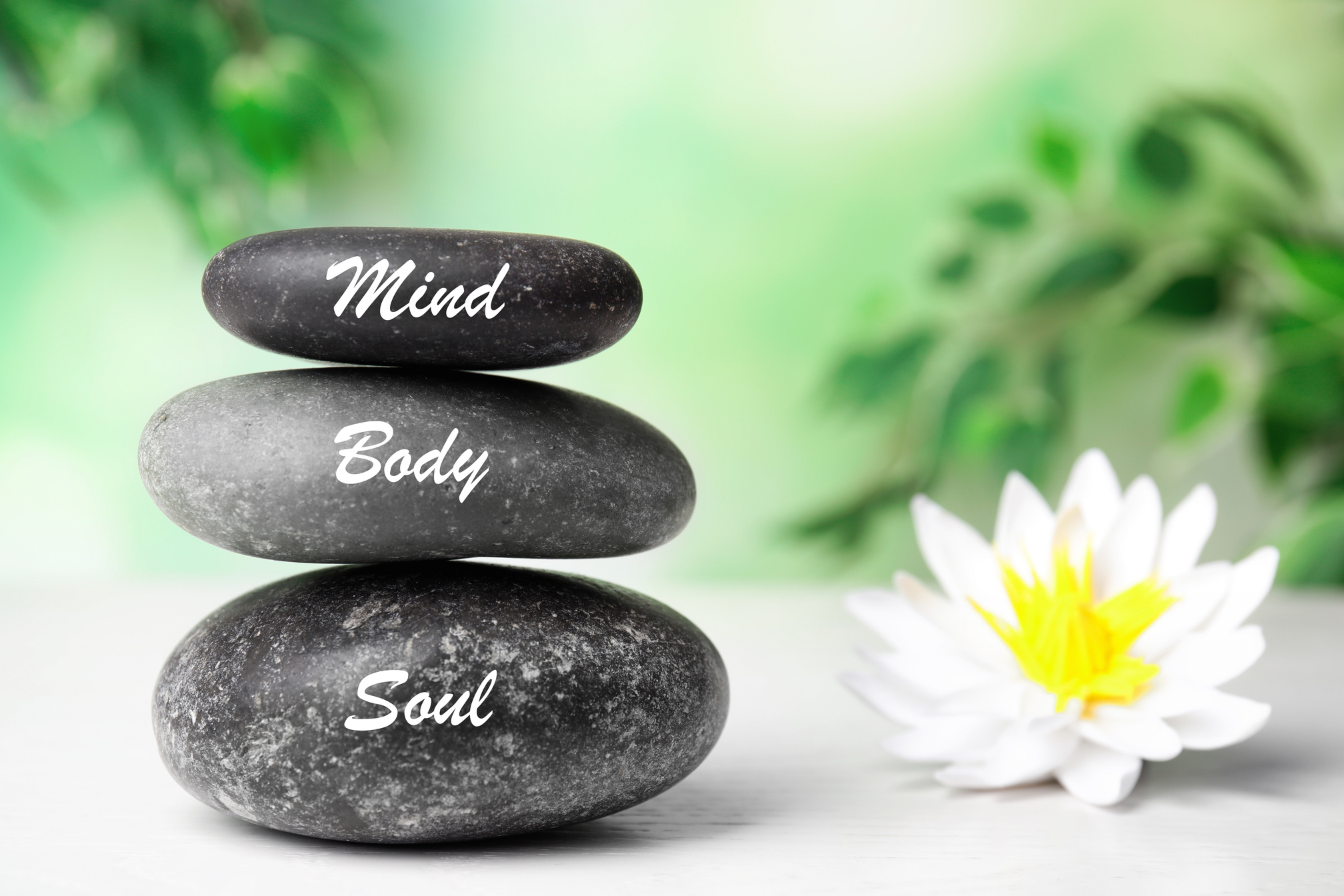 Stones with Words Mind, Body, Soul and Lotus Flower on White Wooden Table. Zen Lifestyle